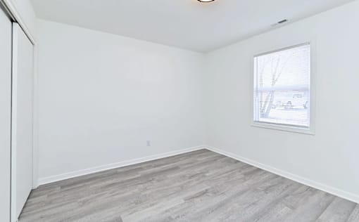 A room with a window and a sliding door.