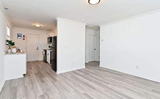 A kitchen area with a refrigerator, a microwave, and a dining table.