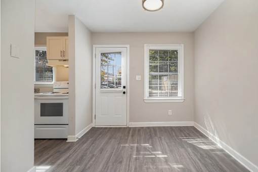 A room with a white door and a window with blinds.