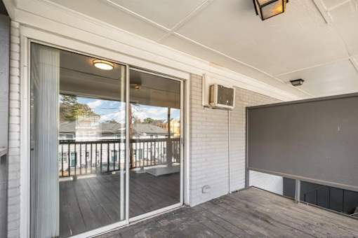 A room with a sliding glass door leading to a balcony.