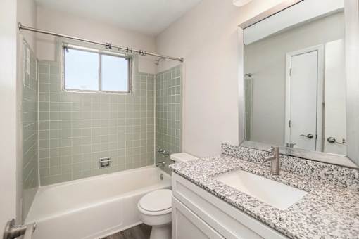 A white bathroom with a tub, toilet, and sink.