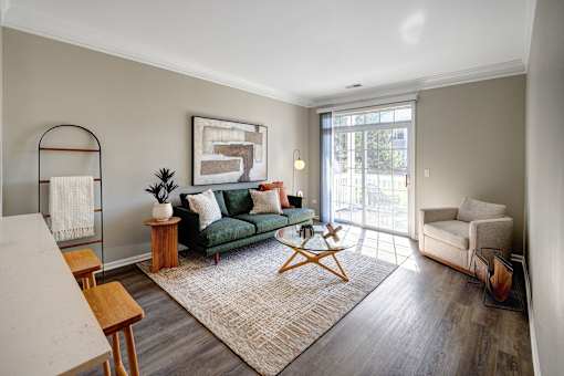 A living room with a green couch and a white chair.