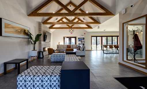 A living room with a wooden ceiling and a large window.