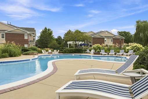A pool with a white and blue striped sun lounger.