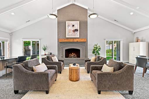 A living room with a fireplace and grey couches.