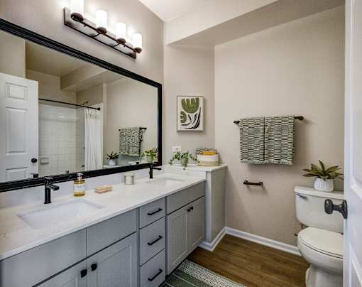 A bathroom with a white toilet, sink, and mirror.