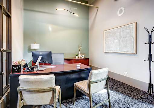 a desk with two chairs in the Ovaltine Court leasing center