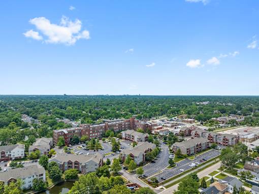 A view of a residential area with apartment buildings and a parking lot.