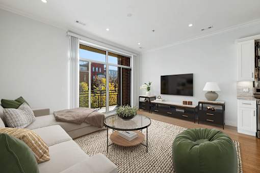 A living room with a white couch, a green chair, and a coffee table.