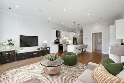 A modern living room with a glass coffee table and a green bean bag chair.
