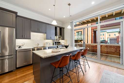 A modern kitchen with a large island and stainless steel appliances.