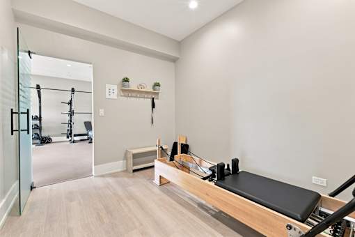 A pilates reformer is in a room with a mirror.