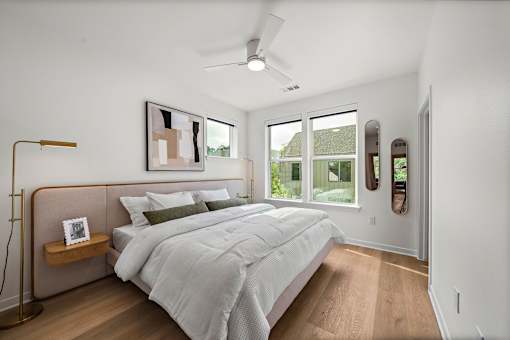 A bedroom with a large bed and a ceiling fan.