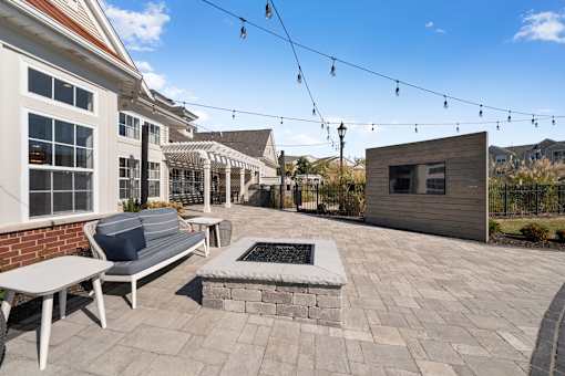 A patio with a bench, table, and a small building.