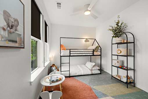 A room with a bunk bed and a shelf with toys on it.
