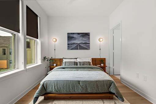 A bedroom with a large bed and a painting on the wall.