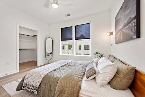 A bedroom with a large bed and a painting on the wall.