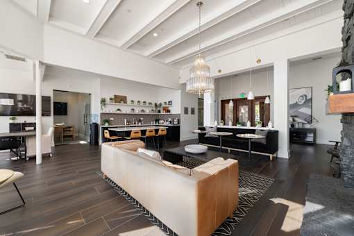 A modern living room with a large wooden coffee table in the center.