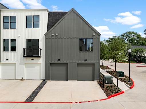 A modern two-story building with a garage door and a white garage door.