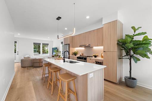 A kitchen with a white countertop and wooden stools.