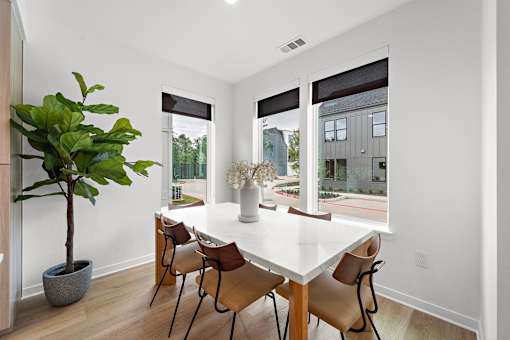 A dining room with a white table and chairs.