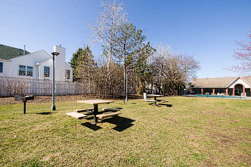 A picnic table sits in the middle of a grassy field.