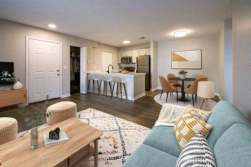 A living room with a couch, chairs, and a dining table.
