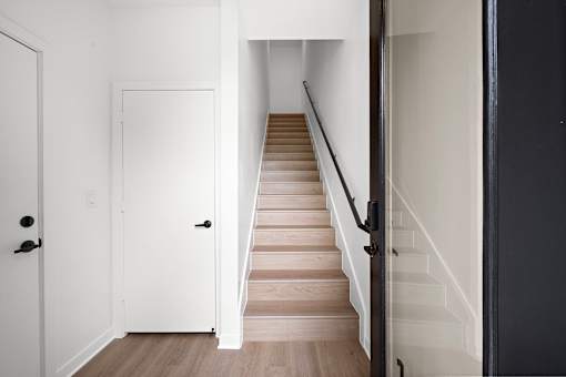 A staircase with a black railing and wooden steps.