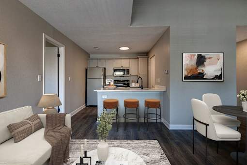 A modern kitchen with a bar stool and a white sofa.