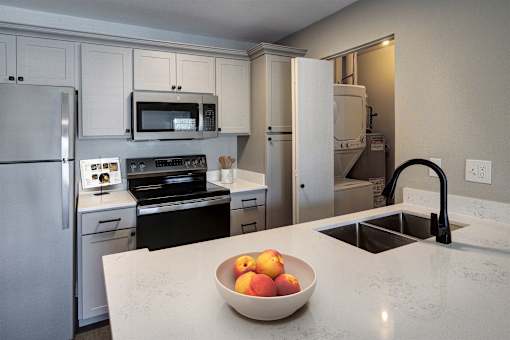 A kitchen with a bowl of fruit on the counter.