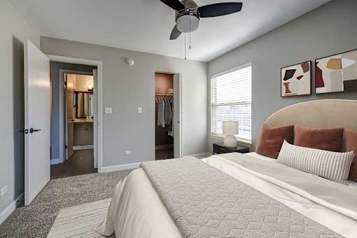 A bedroom with a large bed and a ceiling fan.