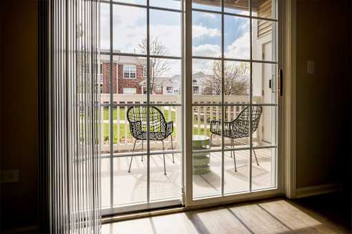 A patio with a table and chairs is visible through a sliding glass door.