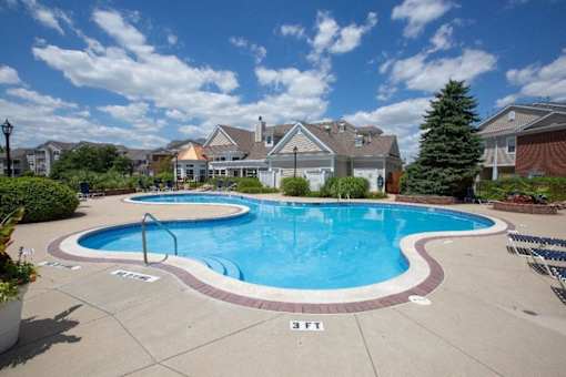a large swimming pool with houses in the background