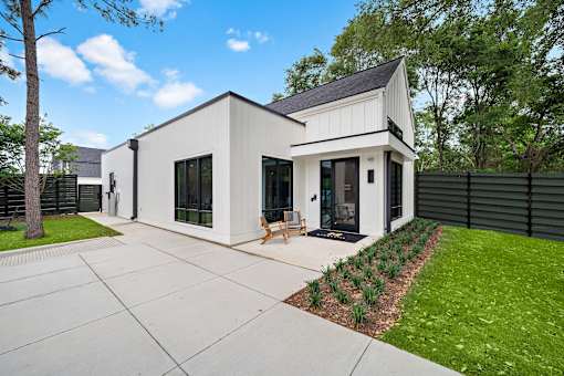 A modern house with a white exterior and a black roof.