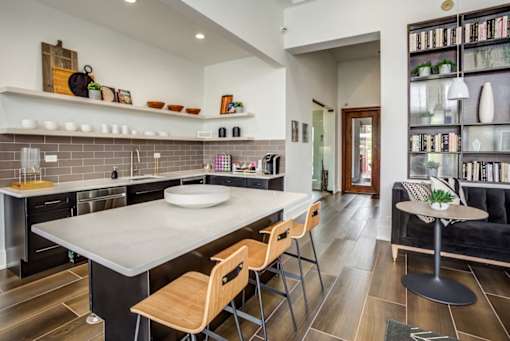 a kitchen with a large island and a table with chairs