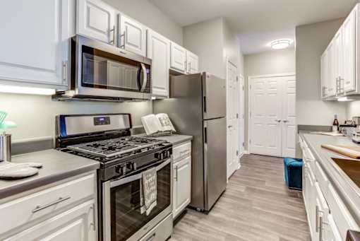 a kitchen with stainless steel appliances and white cabinets