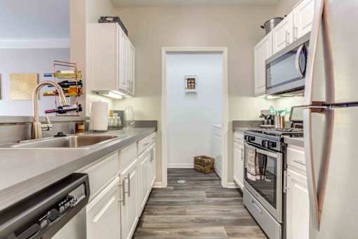 a kitchen with stainless steel appliances and white cabinets