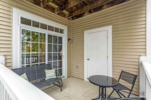 a small porch with a table and chairs and a door