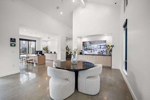 A modern living room with a black table and white chairs.