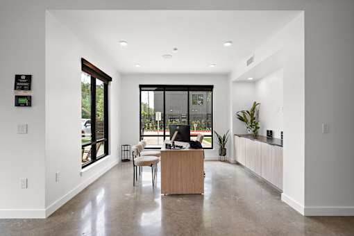 A modern office with a reception desk and a view of the outside.