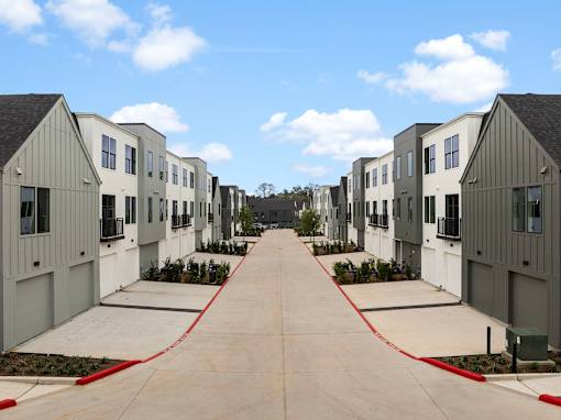 A row of modern houses with a red hose in the middle.