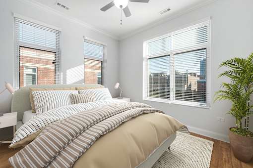 A bedroom with a large bed and a ceiling fan.