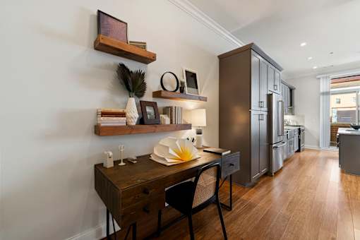 A modern kitchen with dark wood floors and a black chair.
