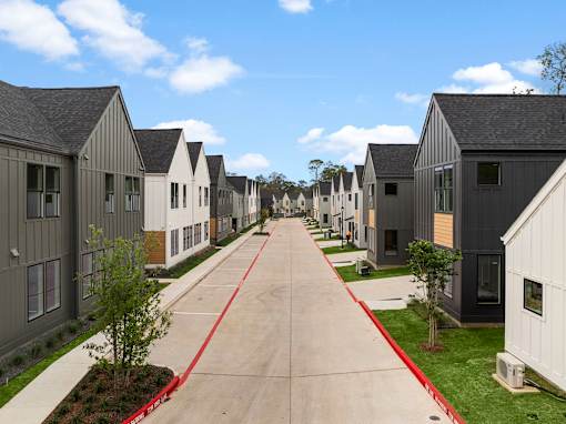 A long row of houses with a red line down the middle of the road.
