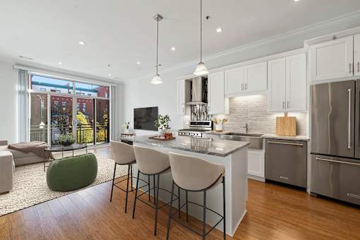 A modern kitchen with a large island and stainless steel appliances.