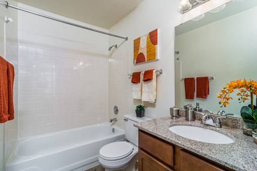 A bathroom with a white tub, toilet, and sink.