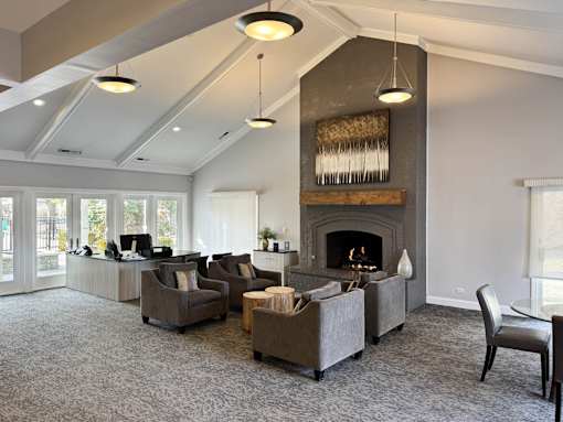 A living room with a fireplace and grey couches.