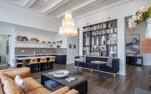 a living room with a kitchen and a couch and chairs