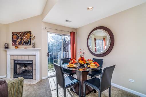 A dining room with a fireplace and a table set for a meal.