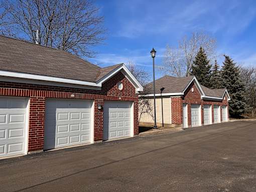 a row of three garage doors on a brick building